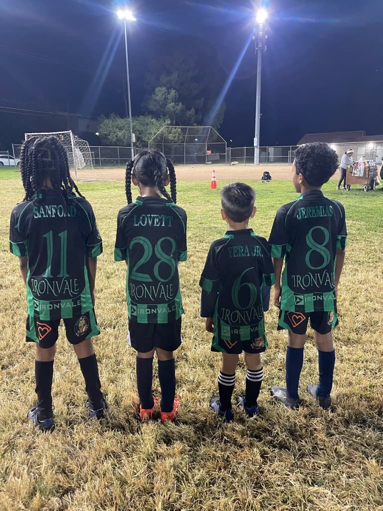 Young Phantom FC players lined up under stadium lights before a night match in the Inland Empire
